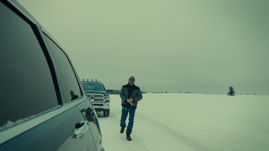 Juan Carlos walks up to a car stopped on the road.