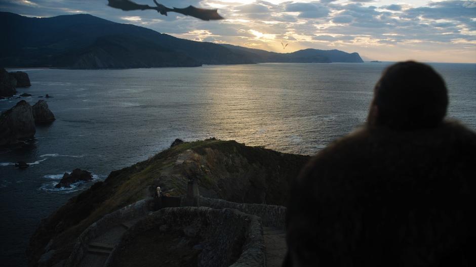 Jon watches Dany as she watches her dragons fly overhead.