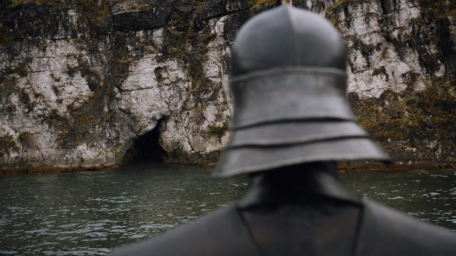 Grey Worm looks at the small tunnel at the base of the cliffs.