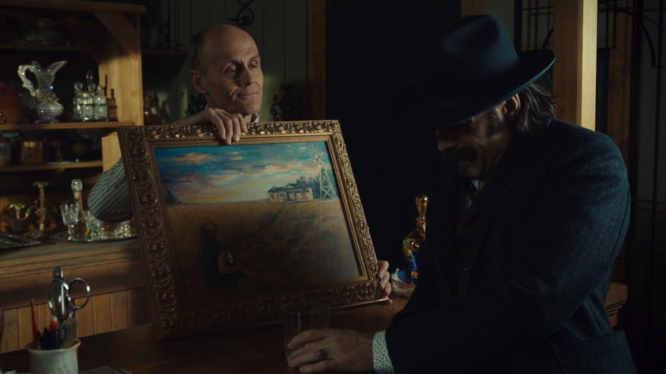 The shopkeeper shows the creepy painting to Doc.