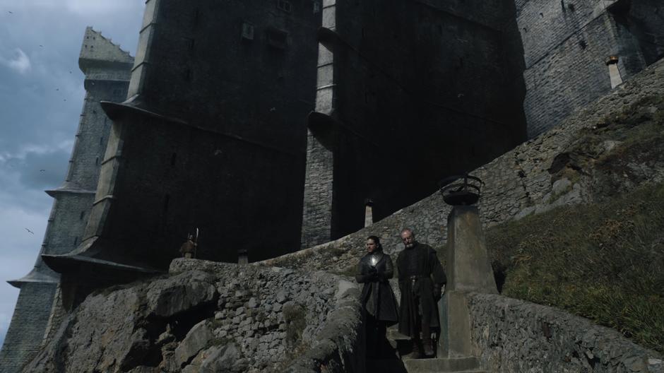 Jon and Davos walk down the steps from the castle.