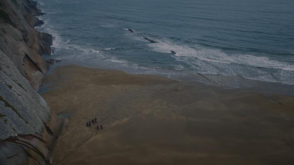 The party of six walks across the beach while Tyrion gives Daenerys the bad news.