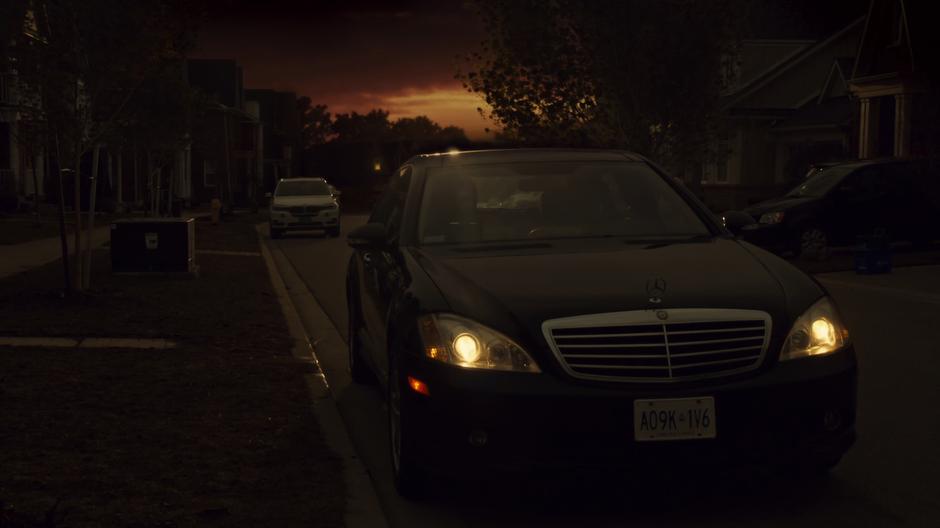 Felix talks to Rachel while sitting in her Uber out front of the house shortly after sunset.