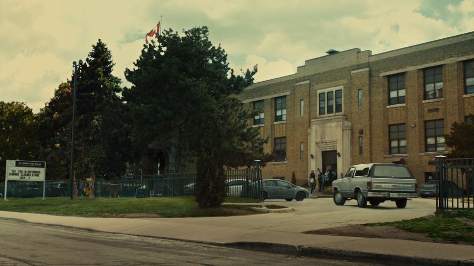 Sarah drives her truck up to the front of the school.