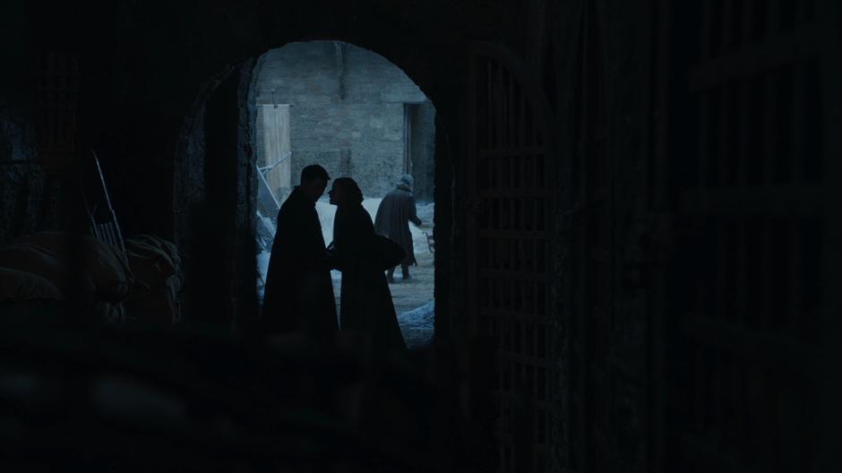 Littlefinger meets with a washerwoman in the shadows.