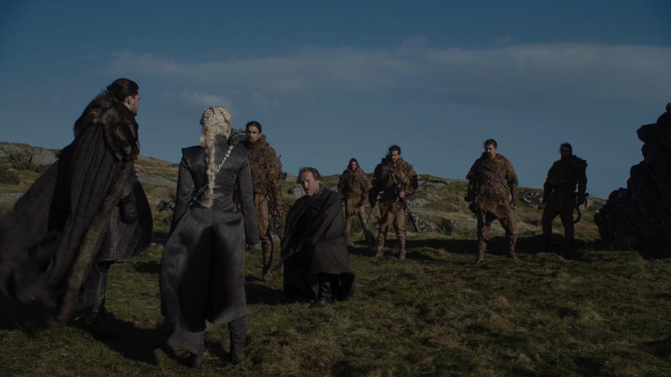 Jorah kneels in front of Dany & Jon after being escorted up by the Dothraki.