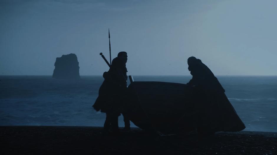 Jon and Davos pull their boat onto the shore.