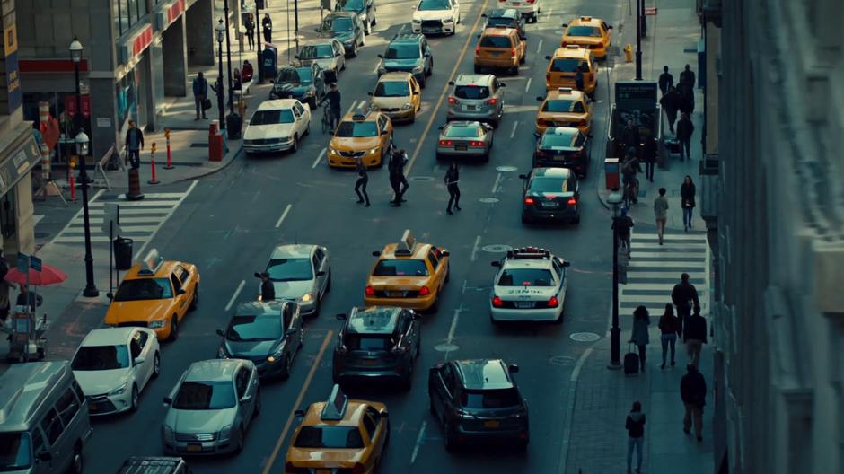 The four shadowhunters stand in a cluster in the middle of the intersection looking to the sky for the creature while mundanes walk around them oblivious.