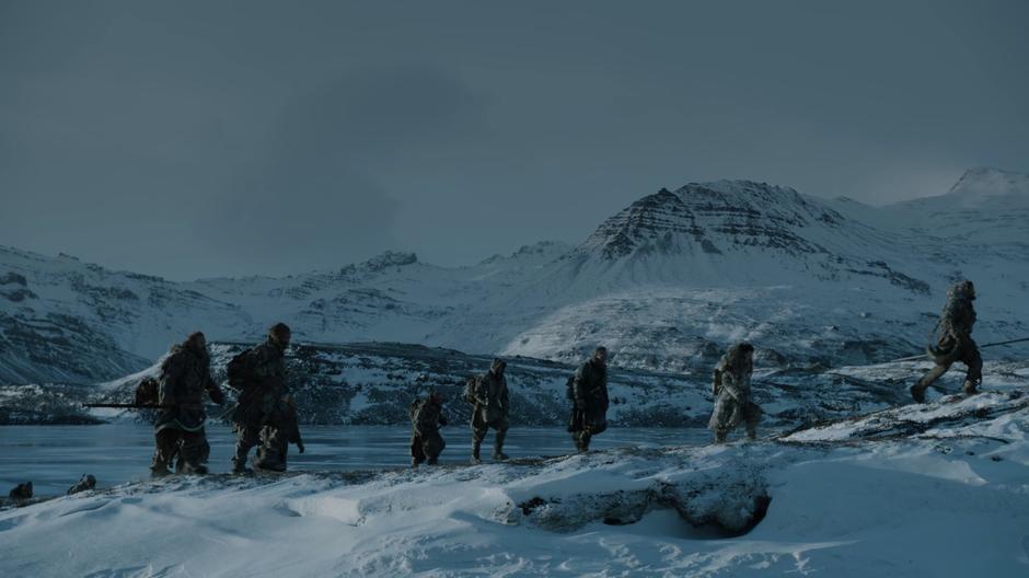 Tormund talks to the Hound as they follow the group up a small hill beside the lake.