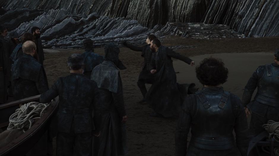 Harrag punches Theon while the other Iron Islanders watch.