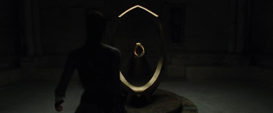 Diana walks up to the lasso hanging from a sculpture in the upper room of the tower.