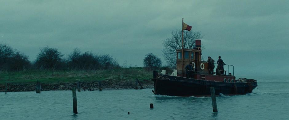 The small boat pulls into the harbor with Diana standing on the deck.