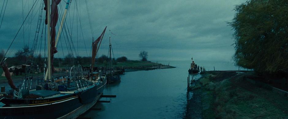 Steve helps Diana off the boat which is docked at the side of the small harbor.