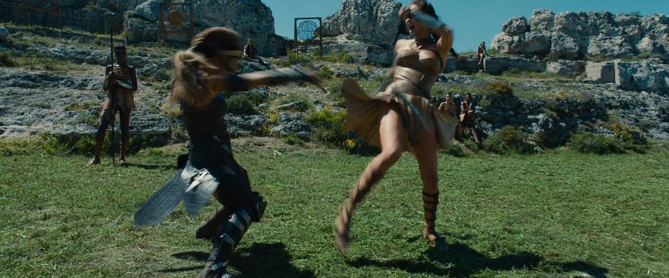 Diana fights with Antiope while several Amazons watch from the background.