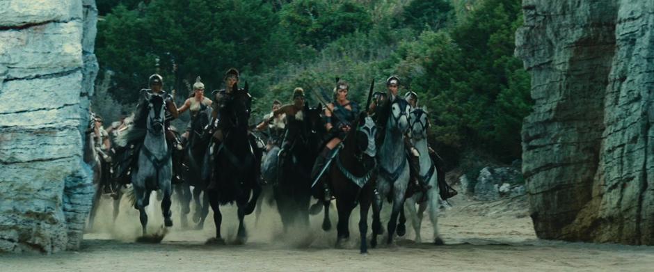 Antiope leads a charge of horses out through a cut in the cliffs.