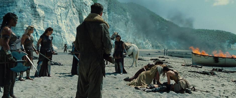 Steve and several other Amazons stand around while Antiope lies dying on the ground surrounded by her sister, niece, and girlfriend.