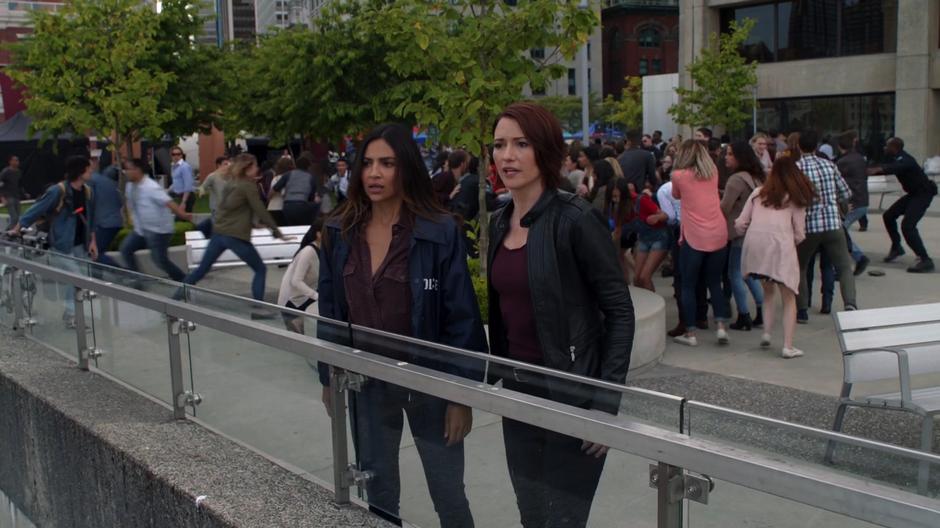 Maggie and Alex look out over the railing as Kara dives underwater.