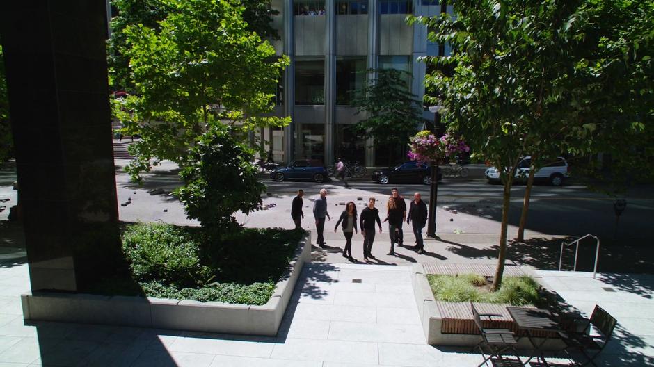 The Legends look behind them to see a T-Rex approaching across the plaza.