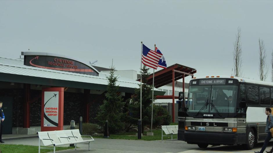 The door of the bus opens as it stops in front of the airport.