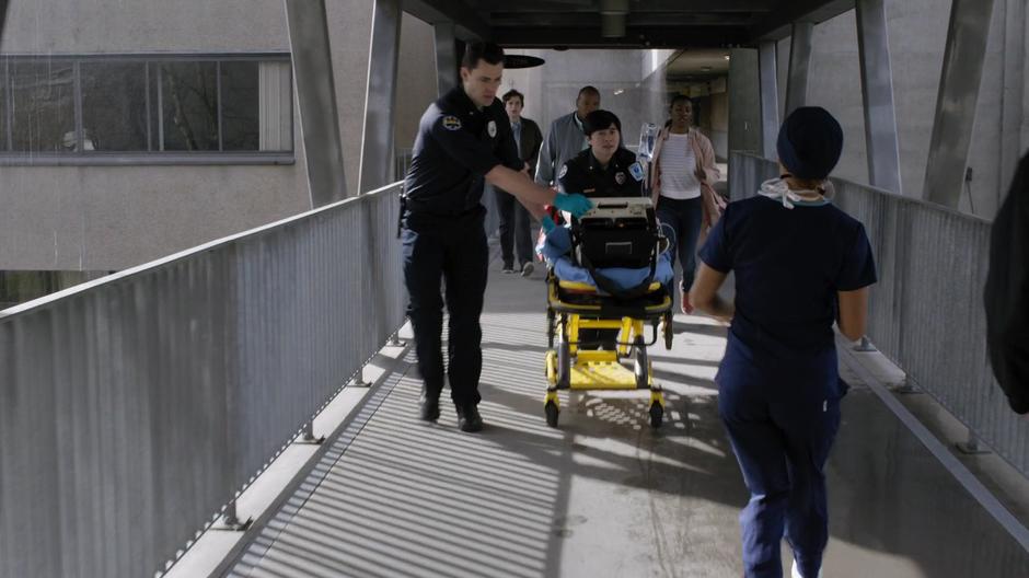 Claire runs up to the paramedics who are wheeling the boy up while Shaun follows behind.