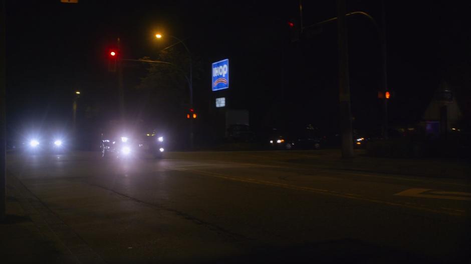 The car drives through the intersection past an IHOP.