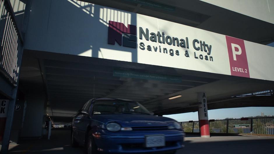 Establishing shot of the bank's parking garage as a car pulls out.