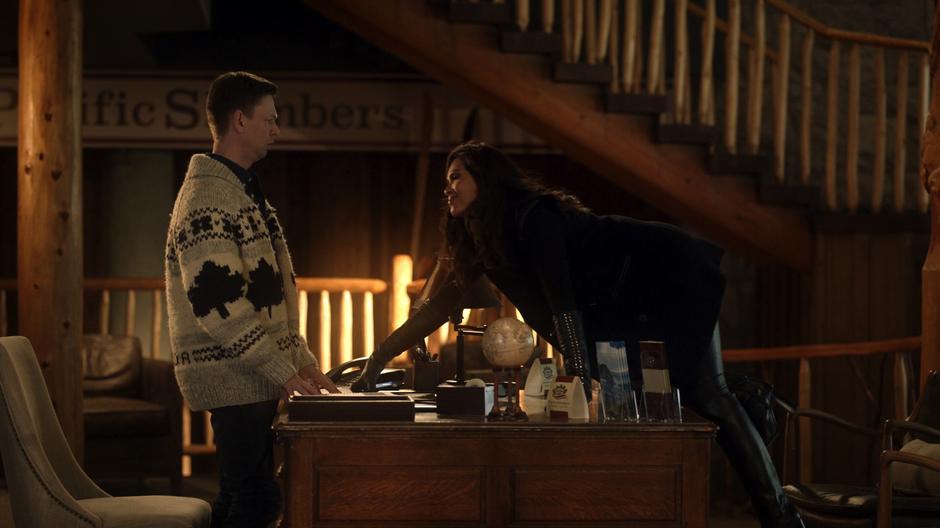 Maze climbs over the desk up to the resort employee who she is trying to get information from.