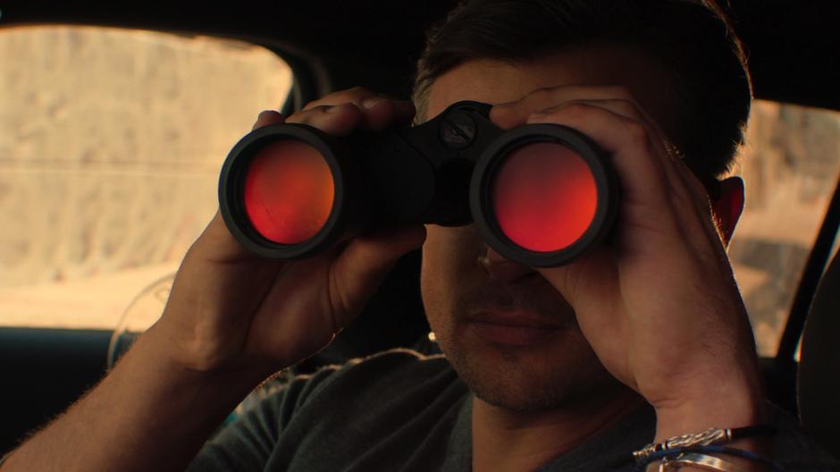Marcus Pierce watches the detectives through binoculars.
