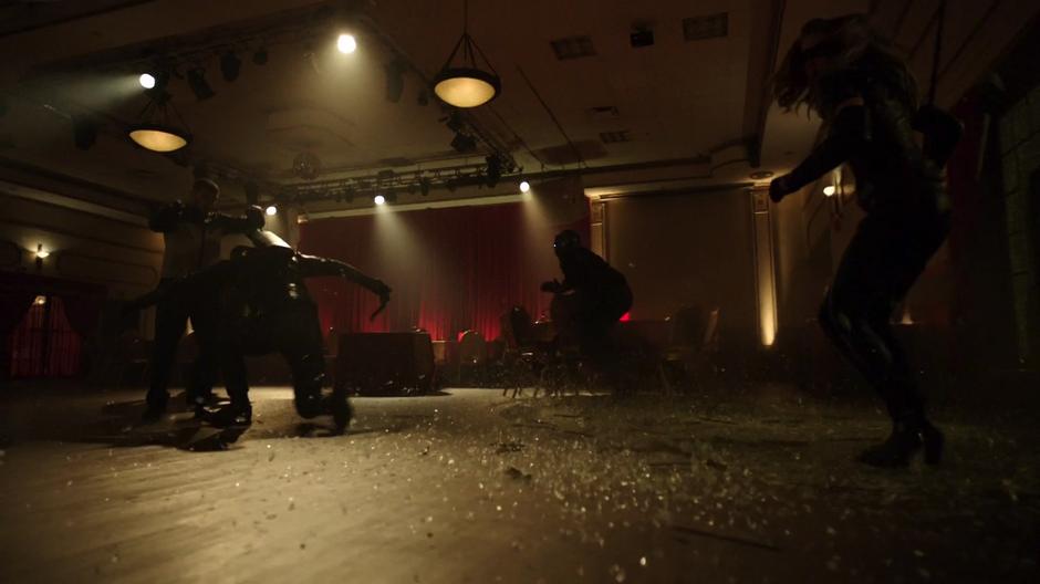 Oliver, Diggle, and Dinah burst into the reception area and attack some of the Bratva guards.