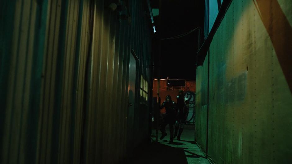 Rene and Curtis search between two of the buildings.