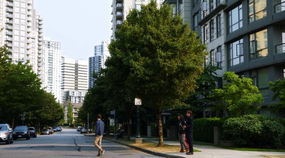 Barry walks into the street and looks up to where the portal opened while Cisco and Wells watch from the curb.