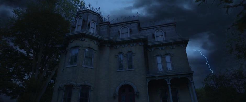 Establishing shot of the mansion at nighttime while lightning strikes in the background.