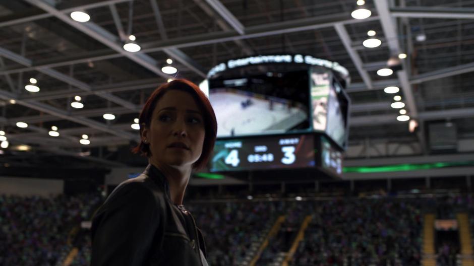 Alex looks back while talking to Kara after seeing the full stadium.