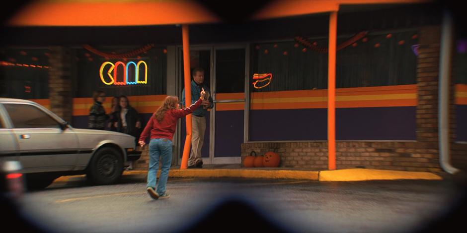 Max flips her step-brother the bird after he drops her off at the arcade.