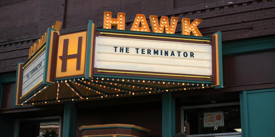 Establishing shot of the cinema with "The Terminator" on the marquee.