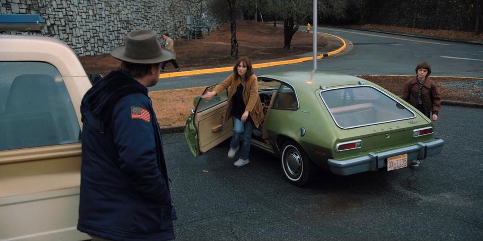 Hopper waits while Joyce and Will get out of their car.