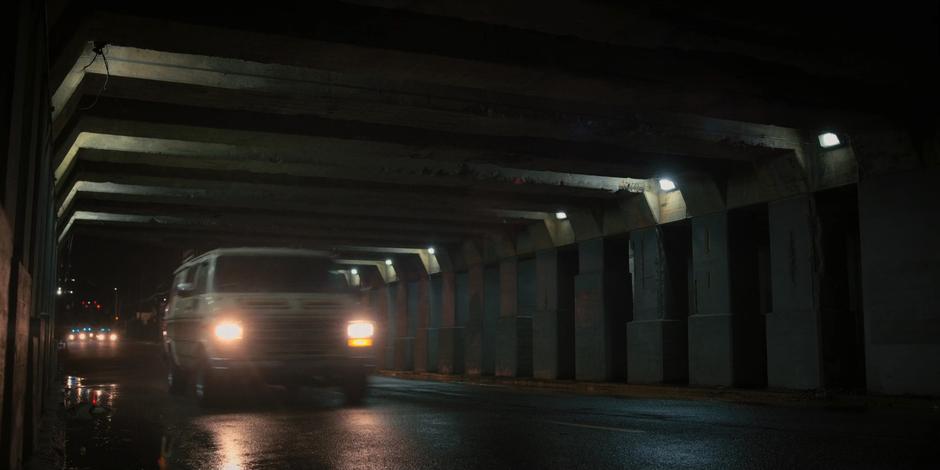 The van drives into the tunnel while three police cars follow from a distance behind.