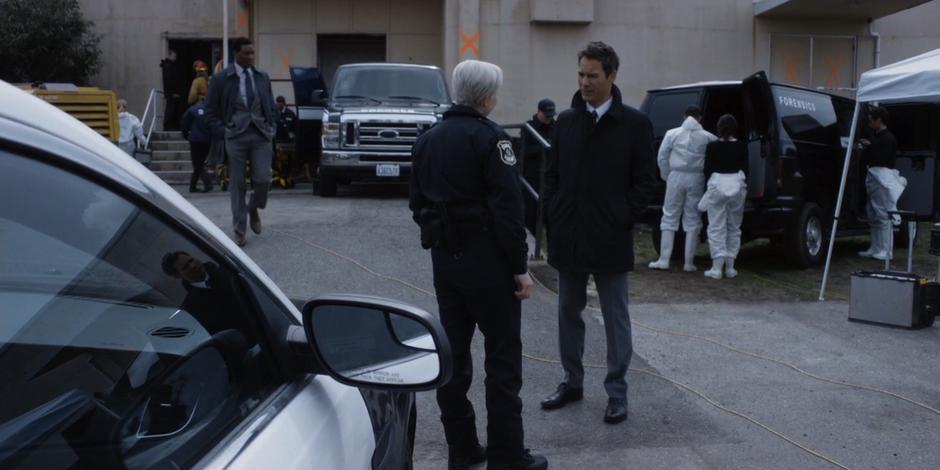 Grant talks to Officer Boyd out front while Walt approaches.