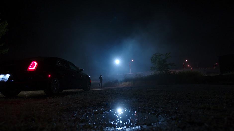 Black Siren stands in the middle of the field as the goon drives away.