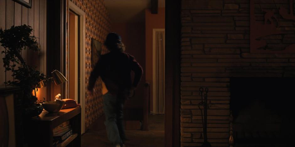 Dustin runs back to his room when he hears the radio going off.