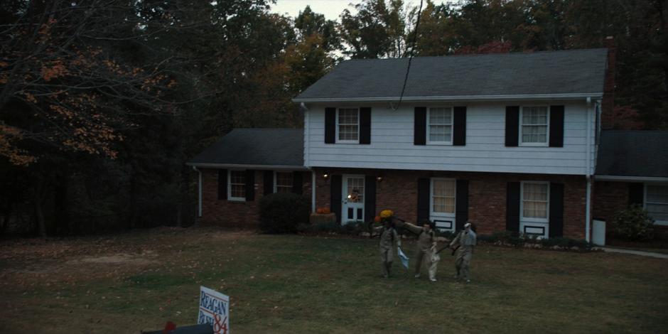 Lucas, Mike, and Dustin wave as Will as they wear their Ghostbusters costumes.