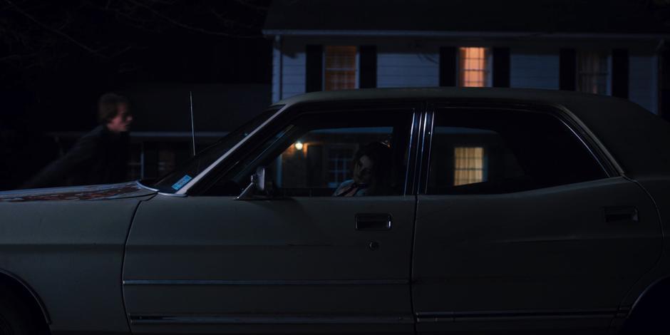 Jonathan walks around to help a very drunk Nancy into the house.