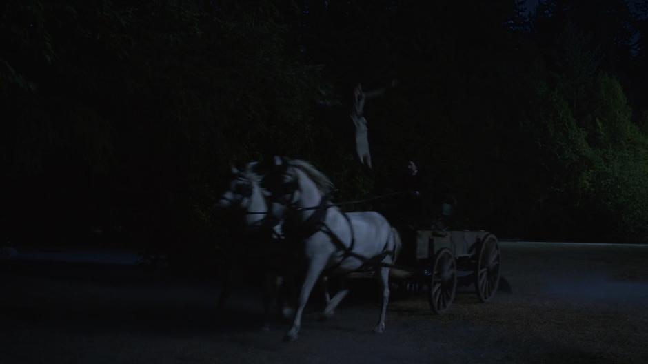 Sara jumps down onto the carriage which is driving through the night.