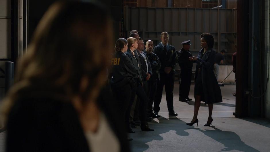 Dinah watches as Agent Watson orders her FBI agents to set up their own perimeter.