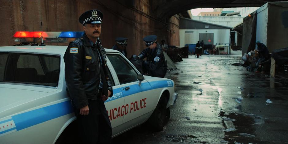 One of the police officers from earlier watches the van drive past.