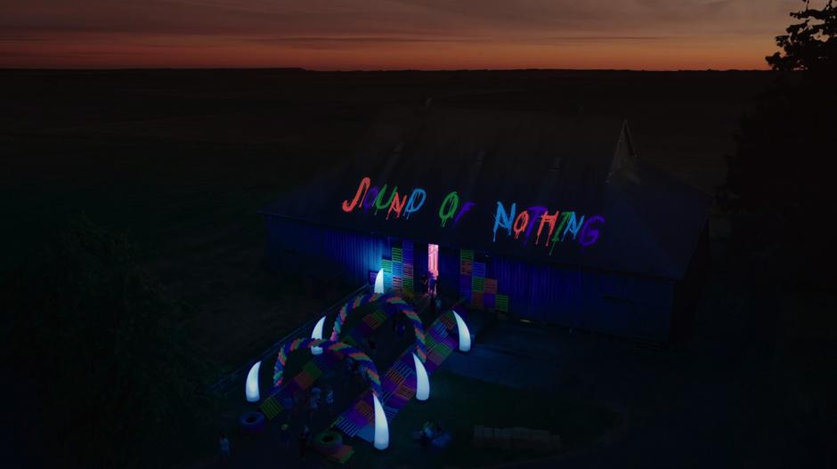 People stream into the music festival which is inside a barn with Sound of Nothing written on the roof in glow-in-the-dark paint.