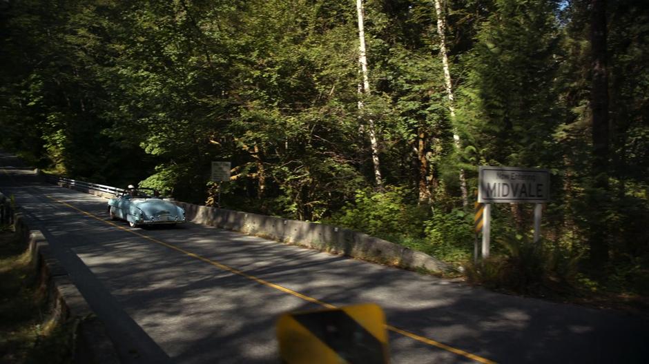 Kara and Alex drive across the bridge into town.