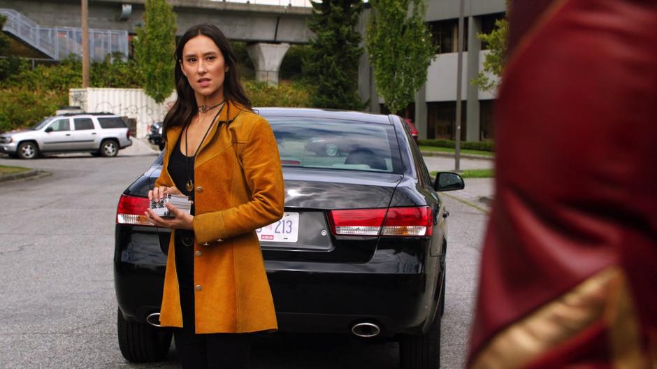 Mina Chayton looks at Barry while holding the box containing the necklace.