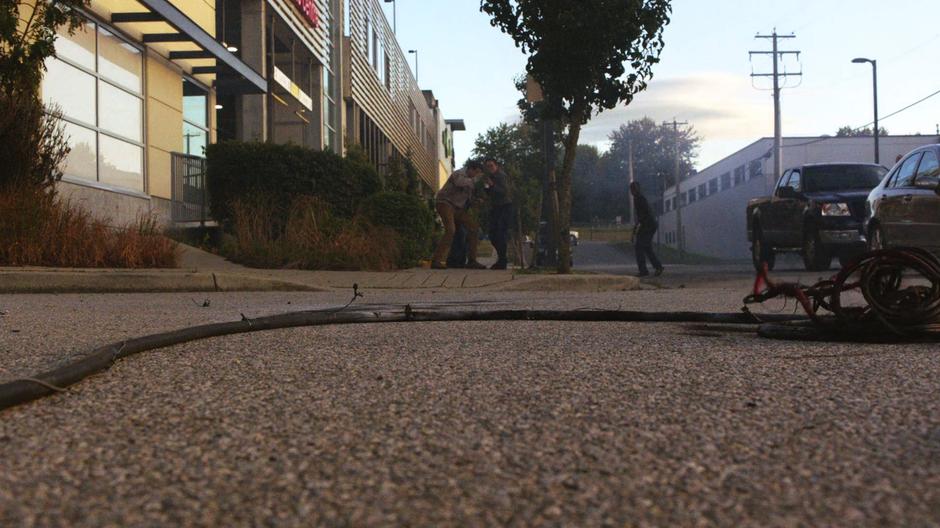 People cower away as a electrical line sparks on the ground.