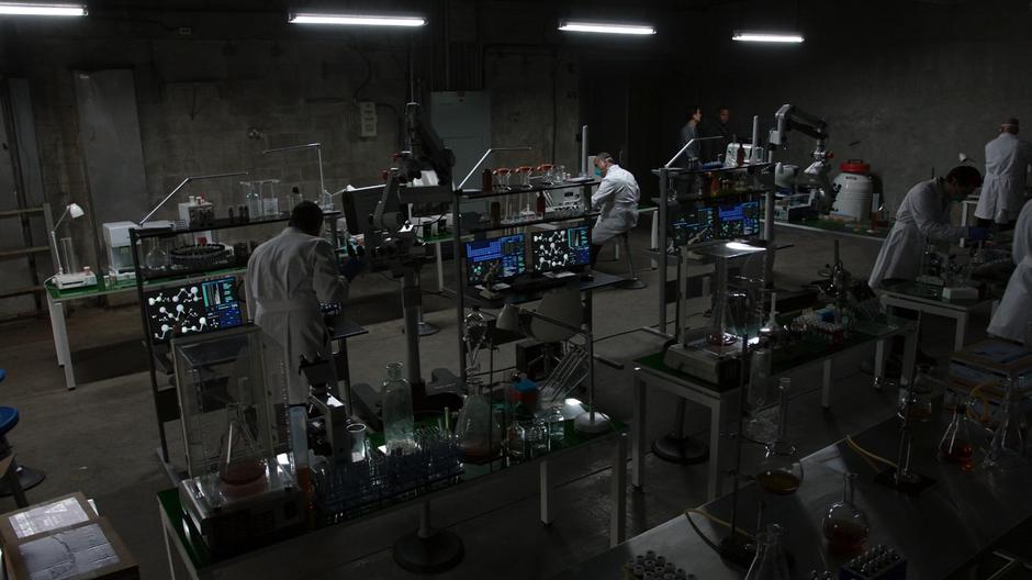 Diggle is escorted into a high-tech drug lab.